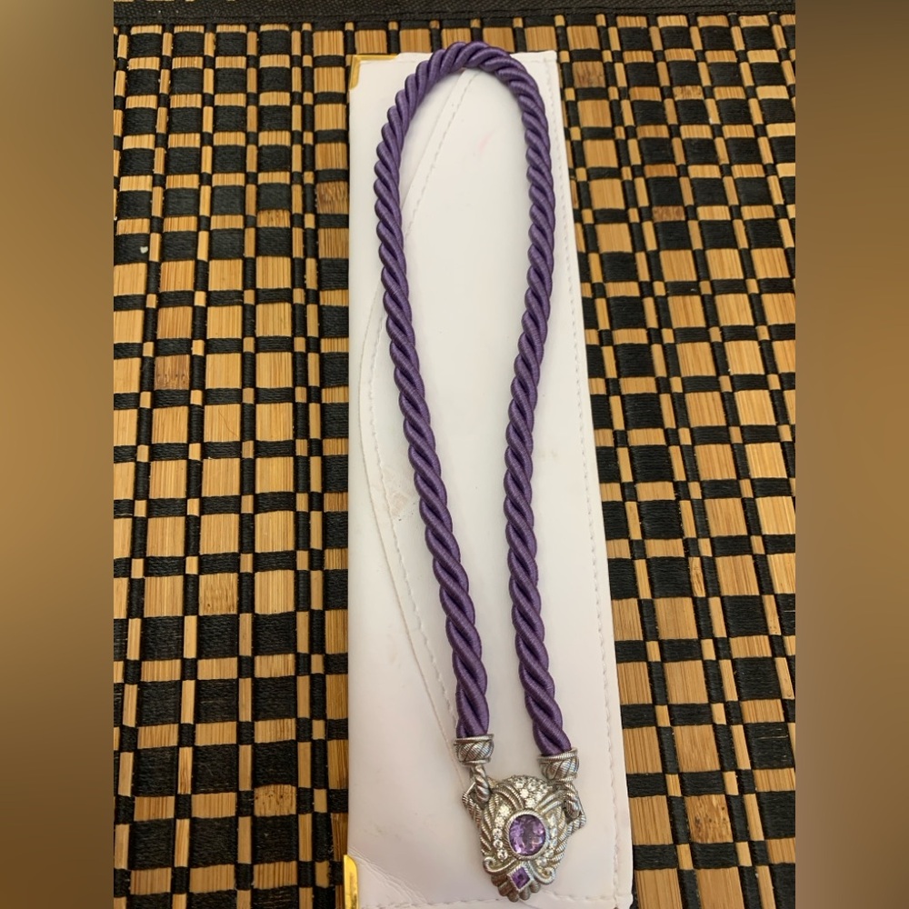 Judith Ripka purple silk chord necklace with silver and purple ornament.